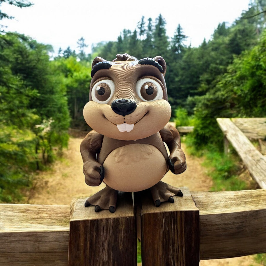 3D printed articulated beaver figure with movable parts, displayed on a wooden fence with a forest background.