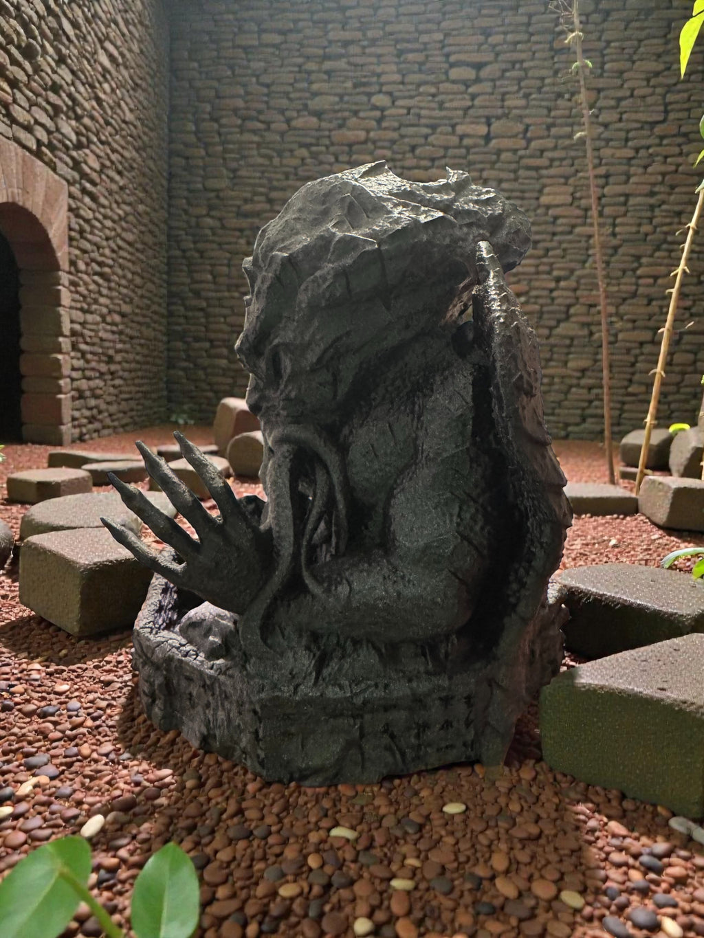 A Cthulhu dice tower facing left in an outdoor setting.