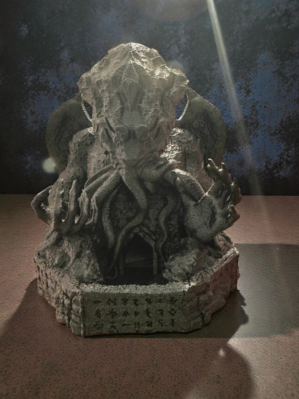 A Cthulhu dice tower with intricate details on a dark background