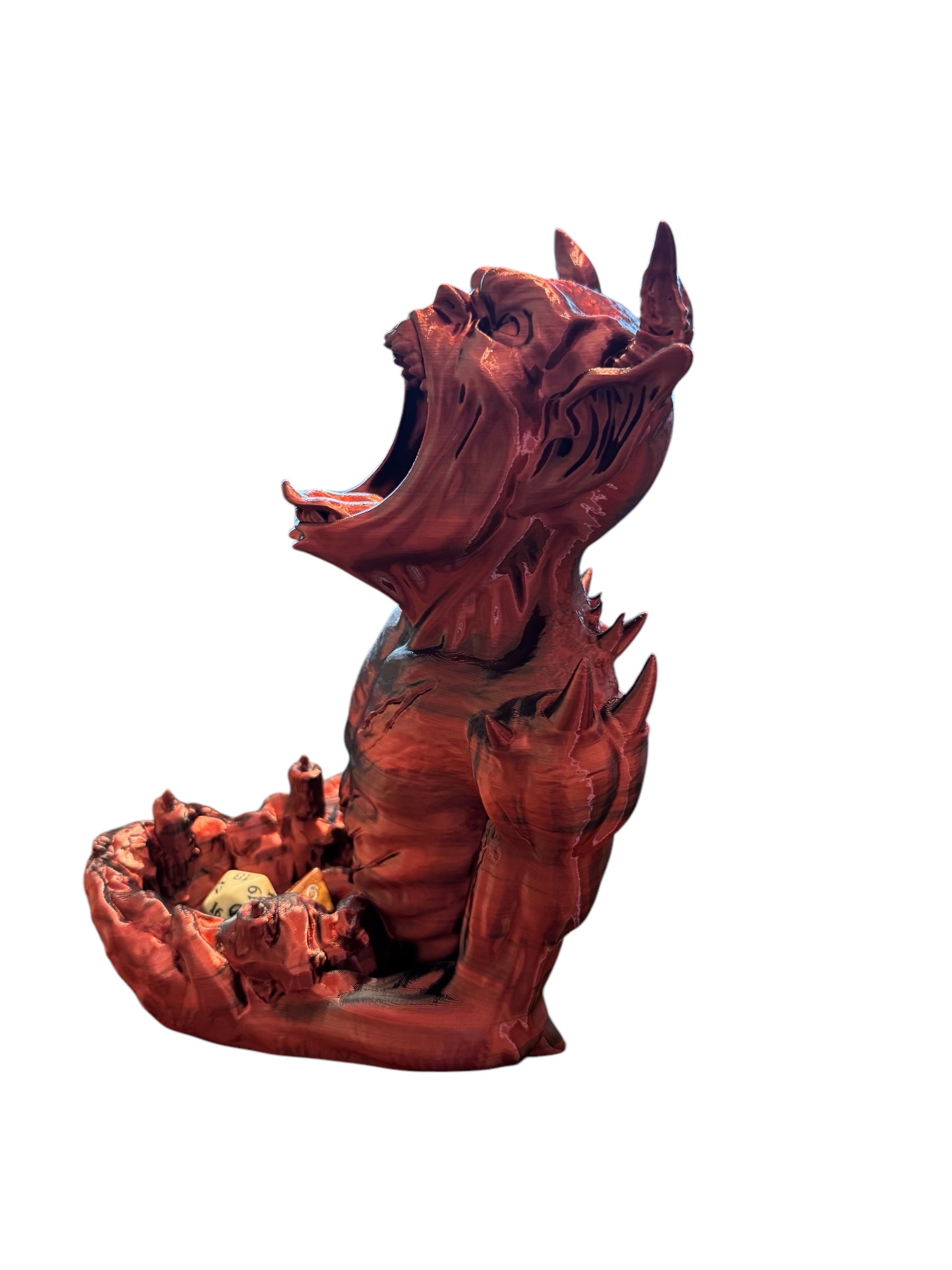 An imp shaped dice tower facing the left side holding some dice on a white background.