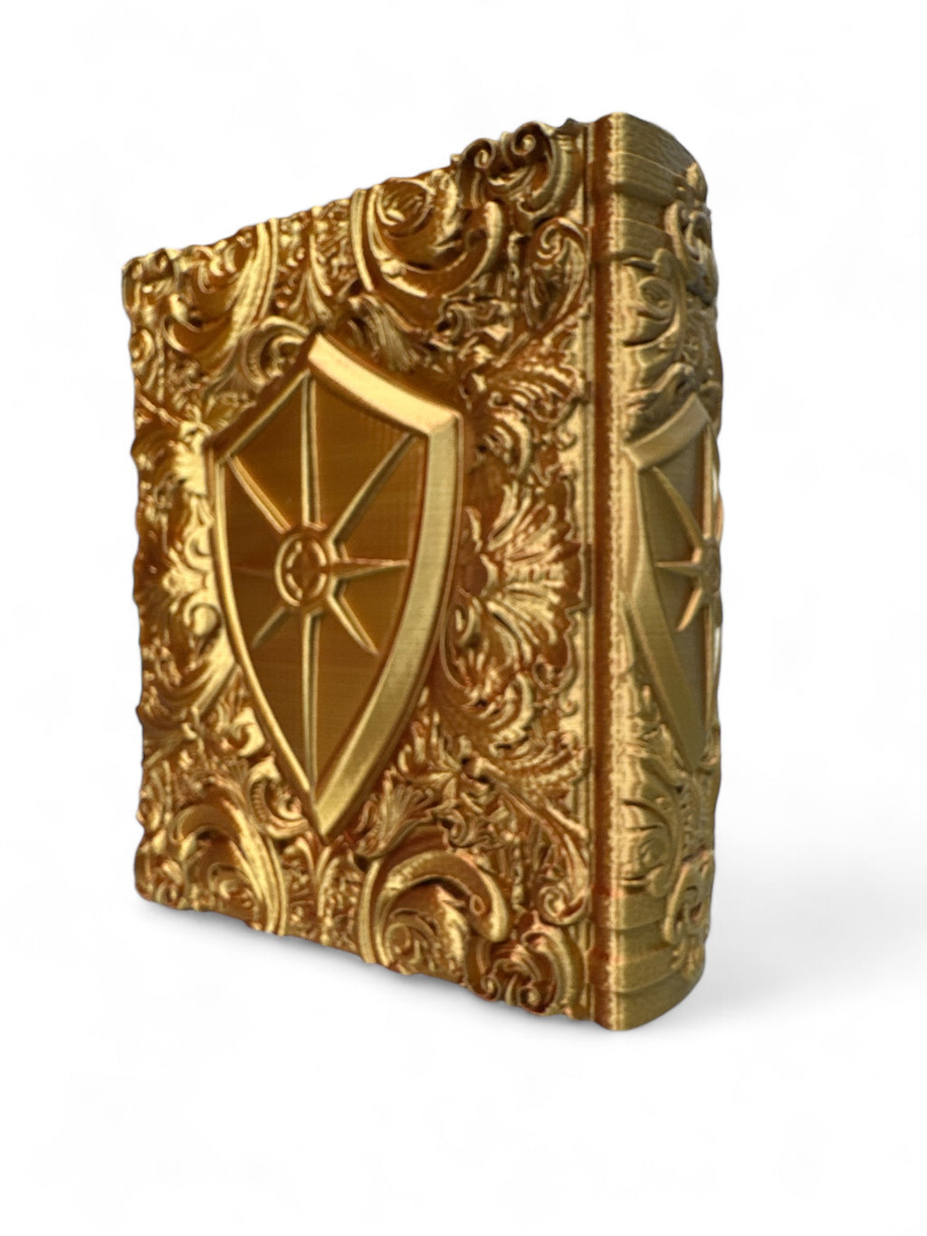A golden 3d printed book with a shield emblazoned with a sun on the spine and cover