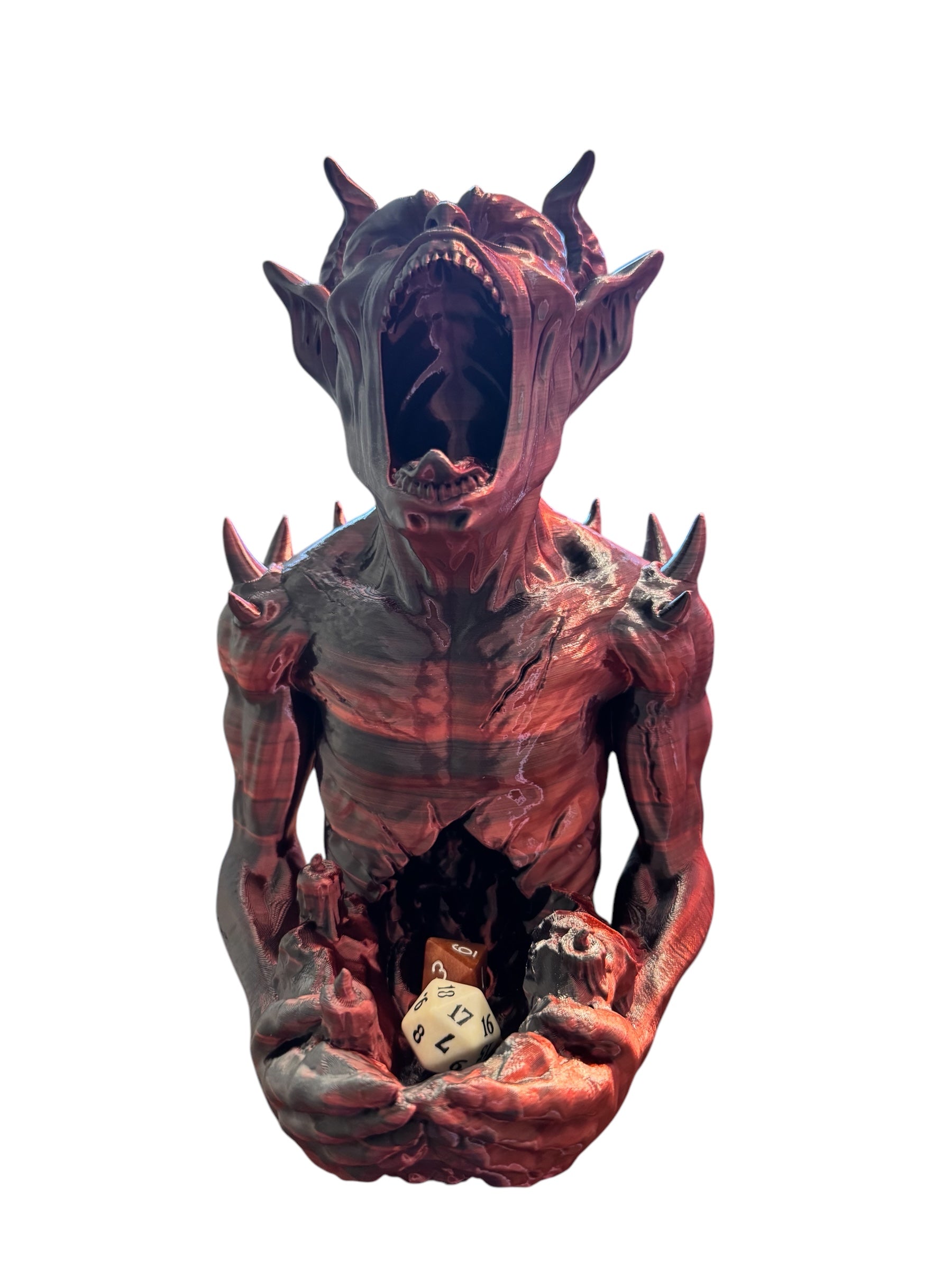 An imp shaped dice tower mouth wide open holding some dice on a white background.